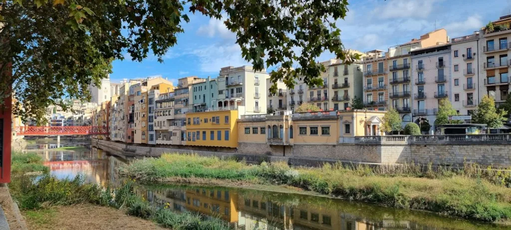 Girona en tren desde Barcelona con casas de colores junto al río Onyar